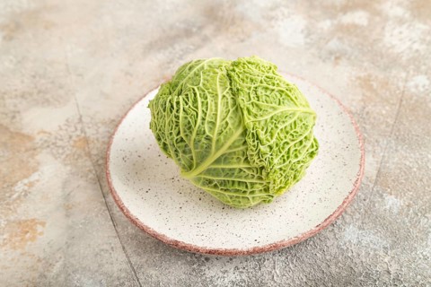 Green lettuce on plate on brown concrete background. Side view, copy space. healthy food,