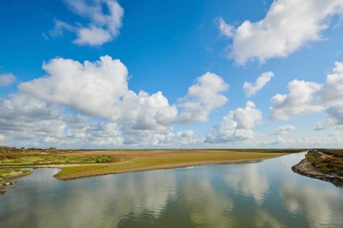 Landscape of clouds flying over a little river, Camargue, France