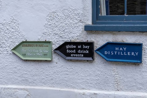 Signpost on house wall, Hay-on-Wye, Wales, Great Britain