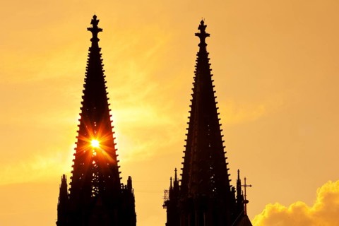 The sun shines through one of the two towers of Cologne Cathedral, Cologne, Rhineland, North