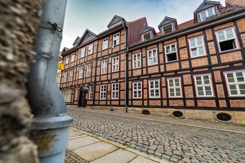 Detailed half-timbered buildings along a cobbled street on a cloudy day, Harz Mountains, Germany