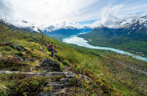 Climbers on a hiking trail, Slaughter Ridge Trail, view of snowy mountains and turquoise lake Kenai