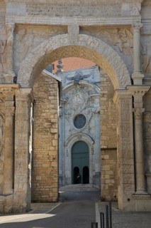 View through the Porte Noire Gallo-Roman arch of honor, Arc de Triomphe at the open church door of