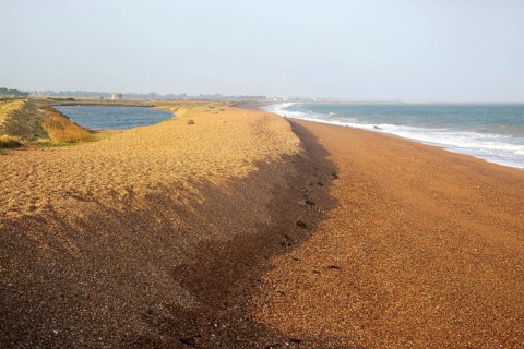 North Sea coastline view of shingle ridge and lagoon on beach bar, Shingle Street, East Lane,