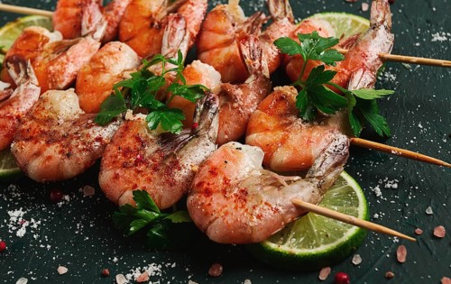 Shrimp kebab, with spices, lime, on wooden skewers, top view, no people