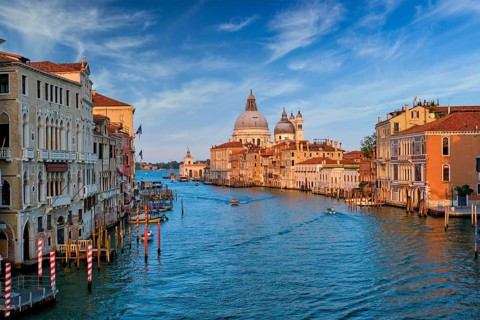 View of Venice Grand Canal with boats and Santa Maria della Salute church on sunset from Ponte