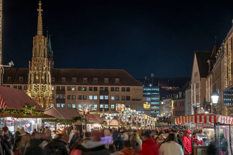 Christkindlesmarkt in Christmas illumination in the evening, on the left the beautiful fountain,