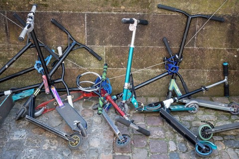 Several scooters attached to each other chaotically, scooters on a house wall, Old Town, Basel,