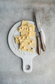 From above view of a white chocolate bar cut into pieces, placed on an ornate vintage cutting board