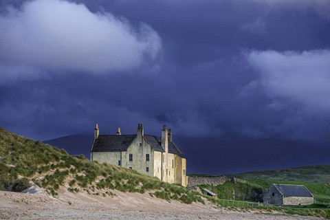 Dark rain clouds rolling in over Balnakeil House, 18th century mansion near Durness, Sutherland,