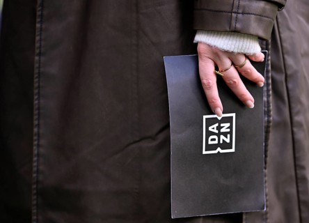 Close-up, hand of DAZN presenter reporter Lisa Tellers holding presentation card logo soccer