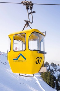 Yellow Hochgrat cable car over snow-covered mountains under blue skies, Hochgrat Mountains, Allgäu