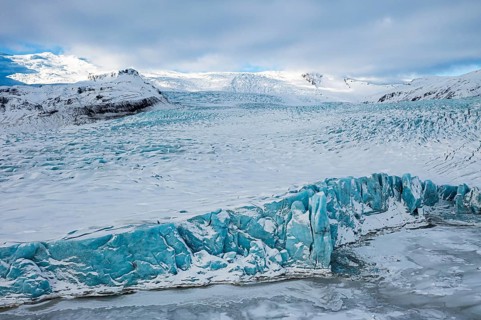 Glacier break in the glacier lagoon Fjallsarlon, behind it the Öraefajökull glacier, drone shot,