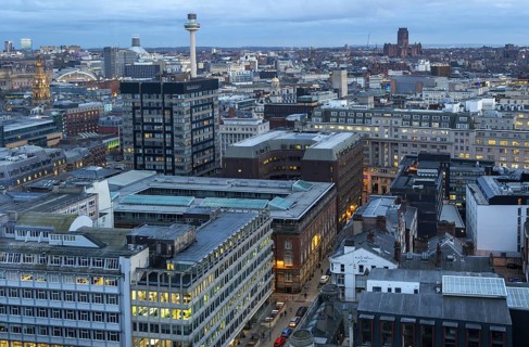 Nighttime view over city centre rooftops office blocks illuminated by lights, Old Hall Street,
