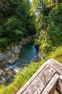 Tolmin gorges in slovenia, showing a wooden railing in the foreground and turquoise water flowing