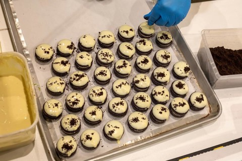 London, Ontario, Canada - A shopkeeper prepares frosted cookies for sale at Covent Garden Market.