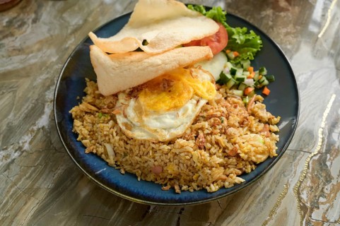 Nasi Goreng Bakso on a blue plate, featuring fried rice with shallots, garlic, sweet soy sauce, and