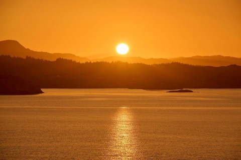Atmospheric landscape scene at sunrise, calm sea and silhouetted islands in the twilight, autumn,