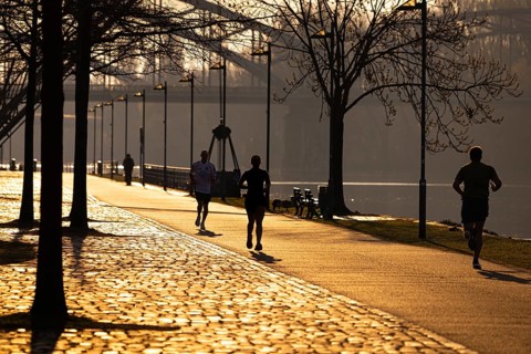 Joggers run along the banks of the Main in Frankfurt in the morning just after sunrise, Frankfurt
