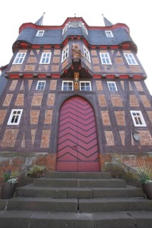 Red-brown house facade with wooden gate, historic town hall, view upwards, brick house, landmark,