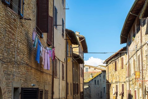 Street with typical houses with shutters, laundry drying in front, San Gimignano, Tuscany, Province