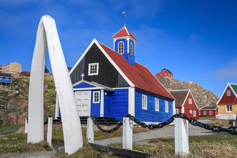 Historical building and whale bones in front of a blue sky, Museum, Sisimiut, West Greenland,