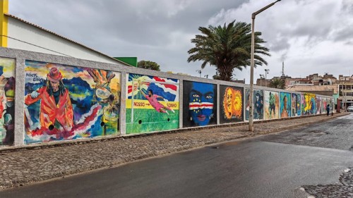 Colourful wall paintings, graffiti with various themes including portraits and cultural symbols,