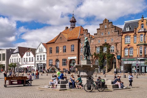 Tine statue of the Asmussen-Woldsen monument or Tine fountain in front of the houses of the old