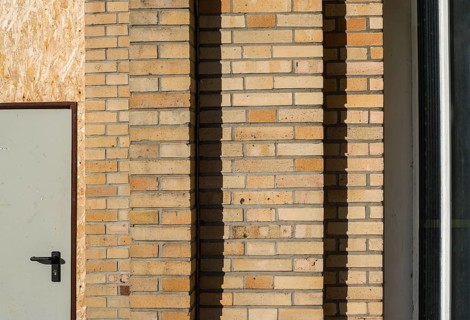 Old building with brick walls and a door covered with OSB panels