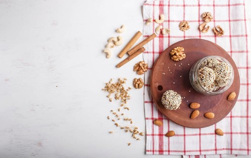 Energy balls cakes with almonds, sesame, cashew, walnuts, dates and germinated wheat on wooden
