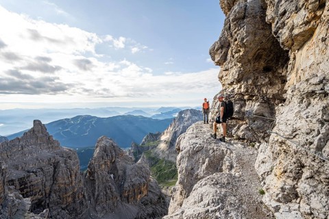 Two mountaineers climb an exposed rock band in the secured Via Ferrata Bocciere Centrale via