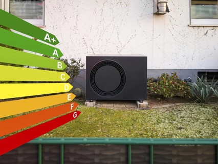 A black heat pump with efficiency classes according to the GEG in a front garden in Langenfeld,