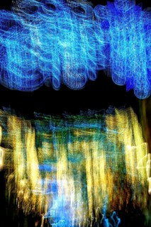 Soft, swirling colors form an abstract landscape of blue and gold lights against a dark background,