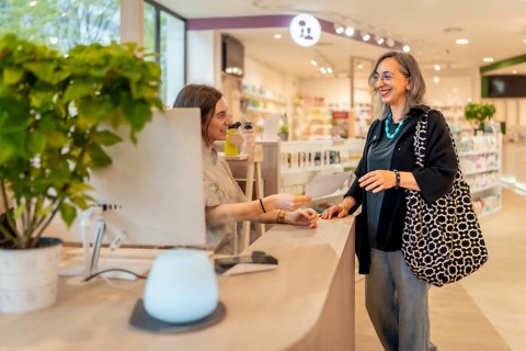 Woman giving a medicine prescription to a pharmacist in the counter of the store