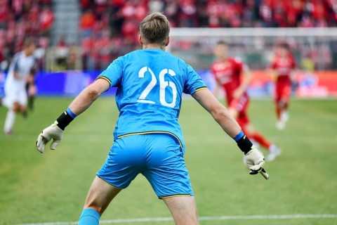 Goalkeeper back's and soccer match in the background in Lodz, Poland