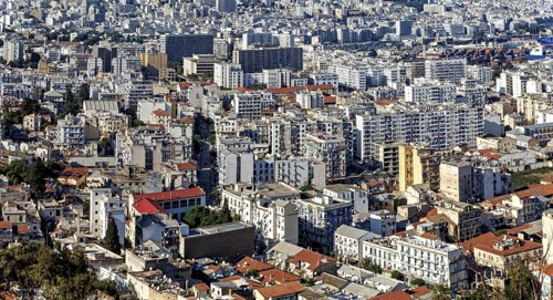 Dense urban landscape with many white and grey buildings in a Mediterranean setting, view of the