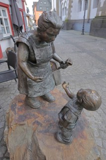 Schnuggel Elsje sculpture by Jutta Reiss, saleswoman giving ice cream cone to child, stretching