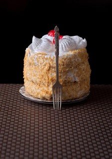 A delectable cake of Tudela, Spain, adorned with meringue and cherries is elegantly showcased with