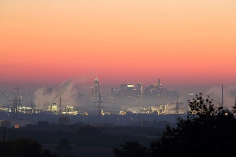 Cityscape on Frankfurt am Main with smoke in front of sunrise, dawn, pollution, air pollution,