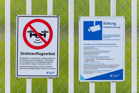 Signs on an airport barrier fence, video surveillance, drone flight ban, Stuttgart,