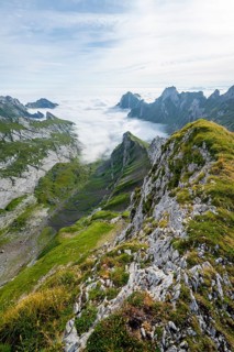 View of mountain peaks above the sea of clouds, Säntis mountains and valley of Meglisalp, high fog,
