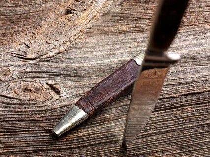 Knife stuck in weathered wood