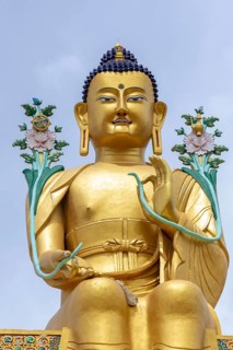 Majestic golden Buddha statue set against the serene backdrop of Zanskar Valley in Ladakh, India.