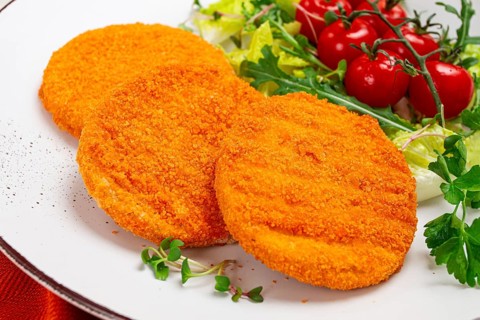 Crispy fried fish cutlets, fish burgers, on a white plate, with fresh lettuce leaves, arugula and