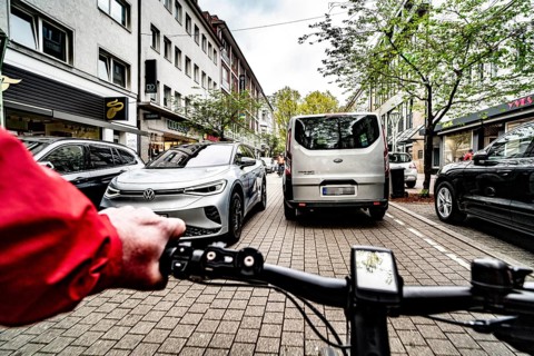 Cycling in the city, inner-city street, cycle lane, bicycles have priority, two-lane traffic with