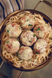 Spaghetti with chicken meatballs, with cream sauce, and parmesan cheese, and decorated with