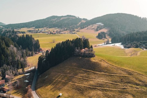 Gentle hills and forests surround a village in a peaceful spring landscape, Oberreute, Allgäu,