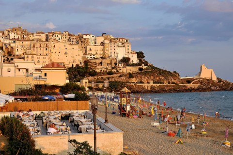 Terrace of a Ristorante Pizzeria at the beach Lido di Fondi, rocky outcrop with historic fortress