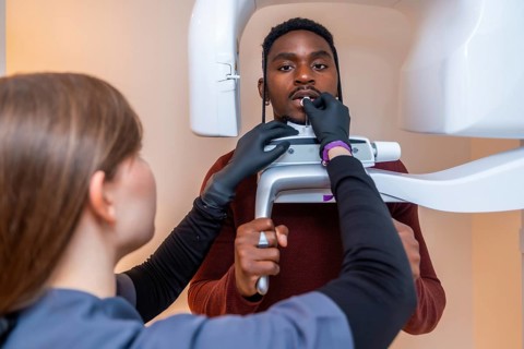 Dental professional preparing a patient for an x ray scan, ensuring precise positioning for a
