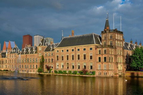 View of the Binnenhof House of Parliament and the Hofvijver lake with downtown skyscrapers in